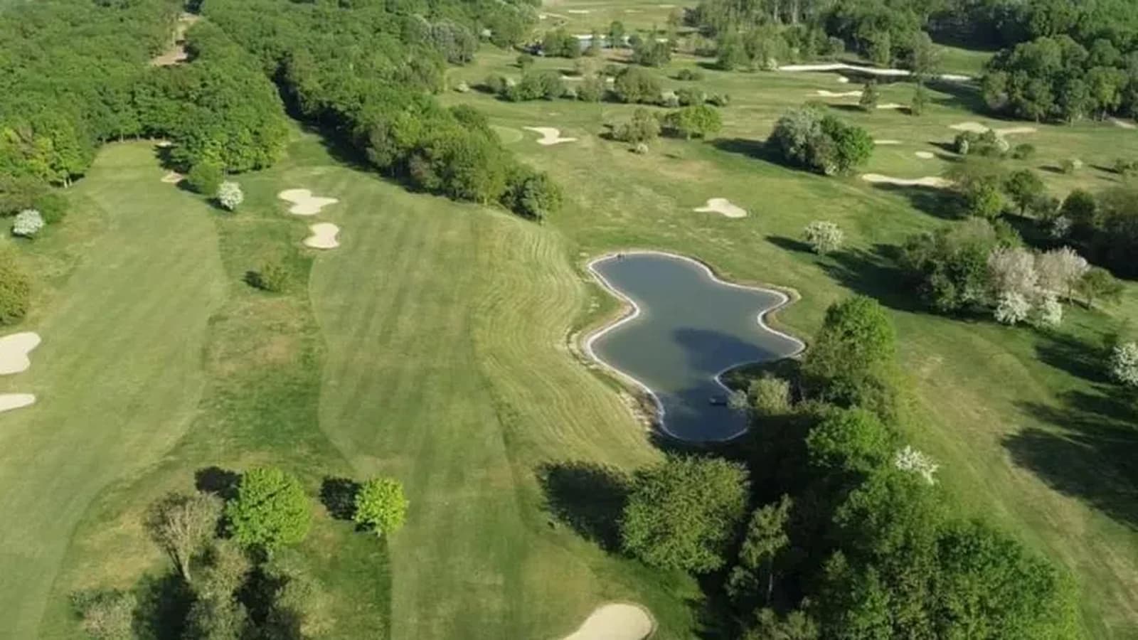 Vue aérienne du parcours arboré et de son plan d’eau au Golf de Guerville.