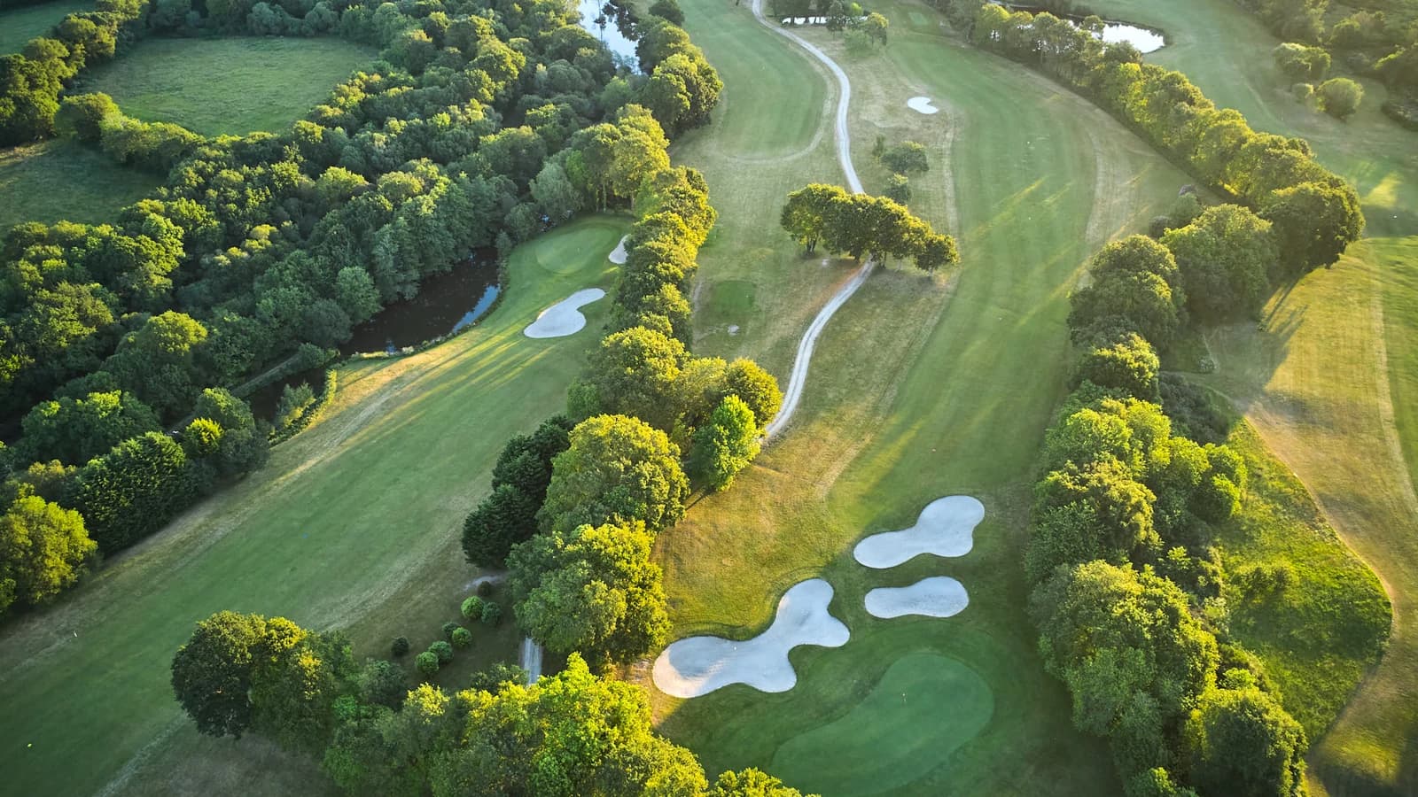 Vue aérienne des fairways boisés et des bunkers du Golf Bluegreen l’Odet.