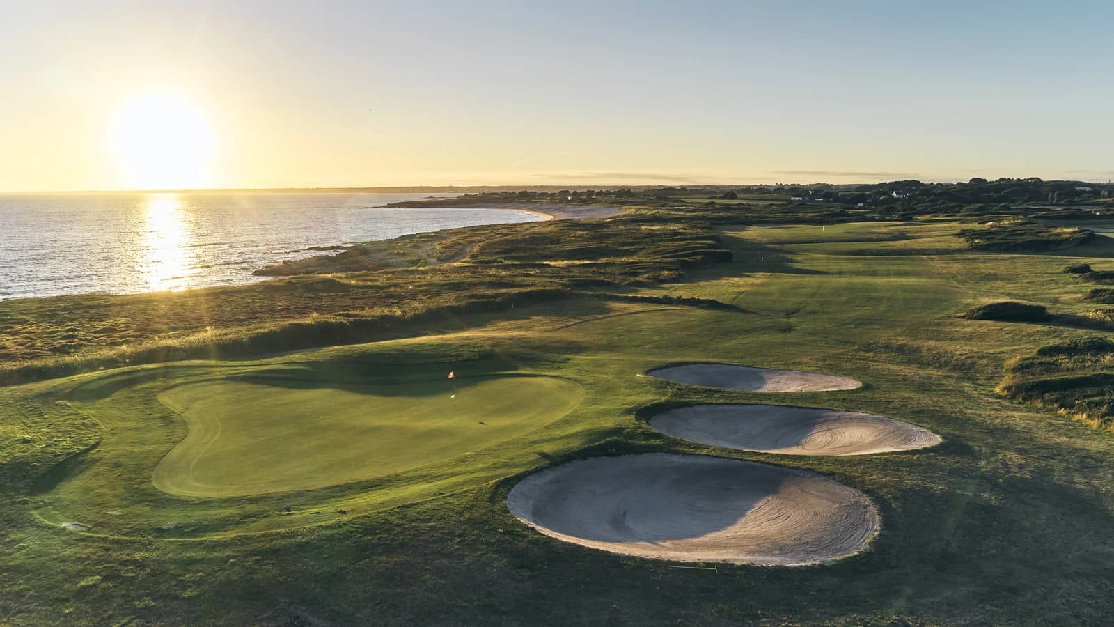 Green et bunkers du Golf Bluegreen Ploemeur Océan au soleil couchant, face à l’Atlantique.