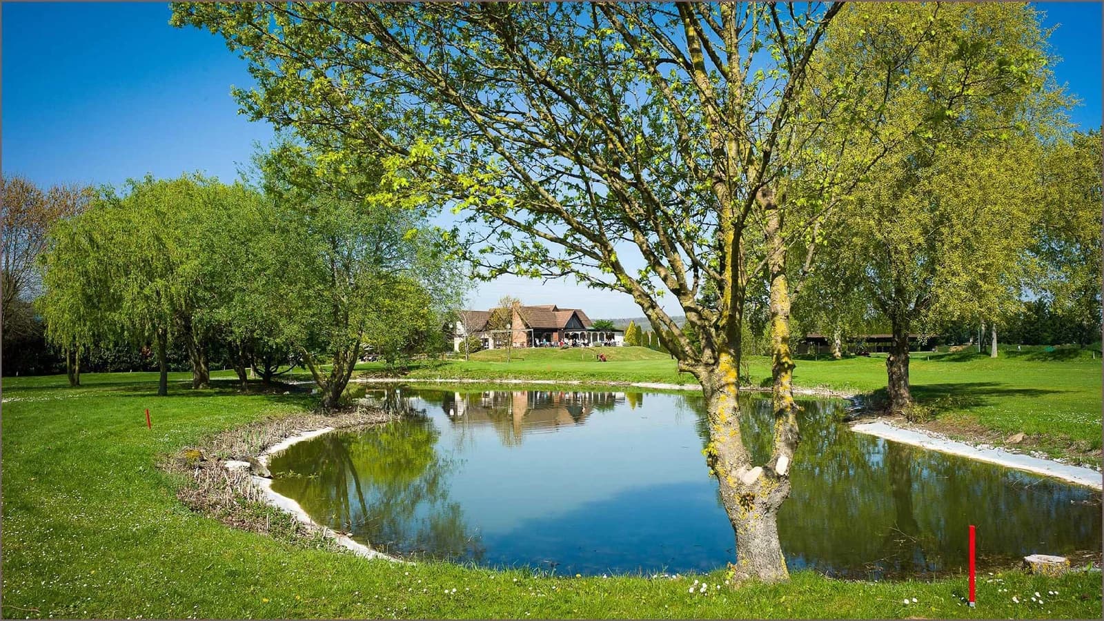 Green bordé d’un plan d’eau au Golf de Gaillon.