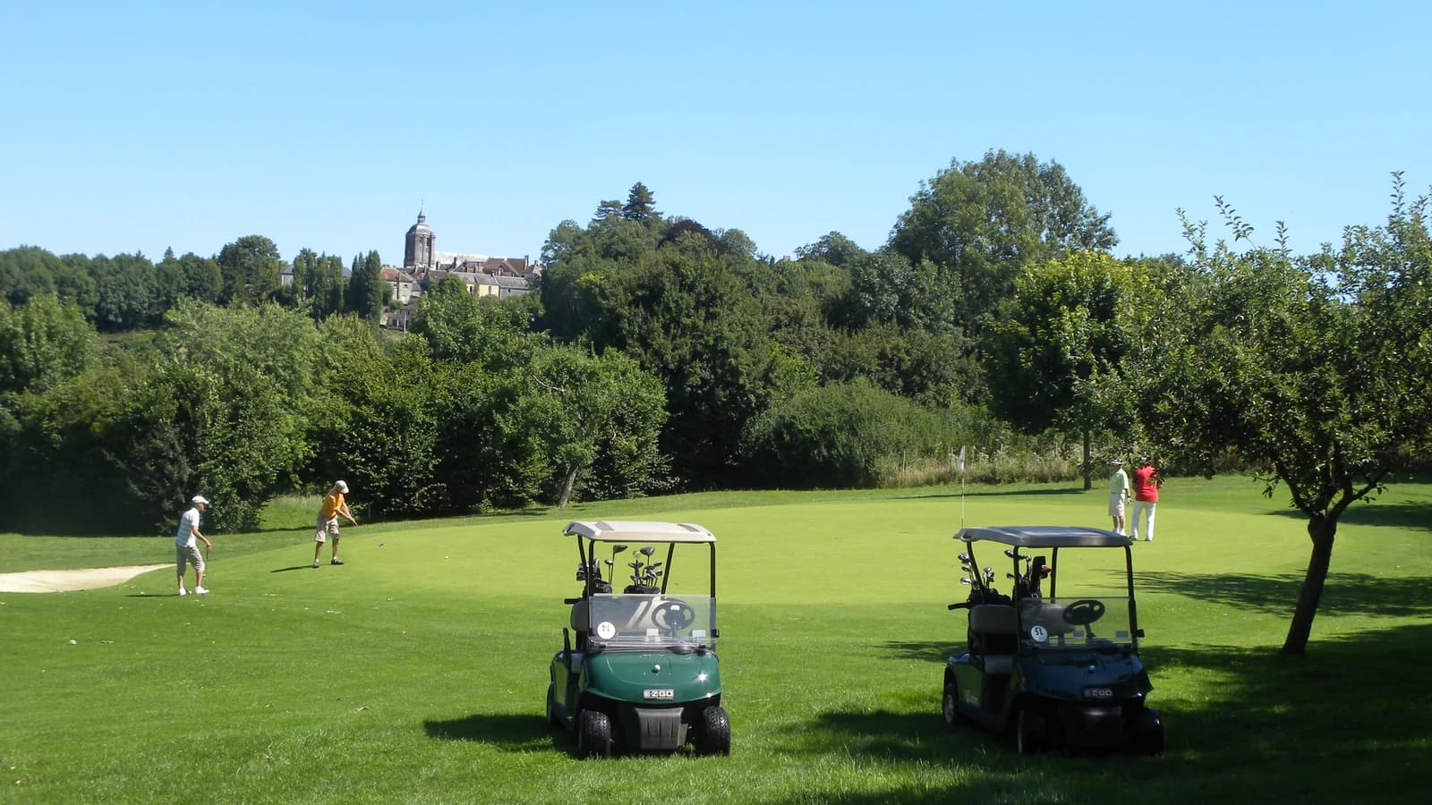 Green du Golf de Bellême avec golfeurs et voiturettes.