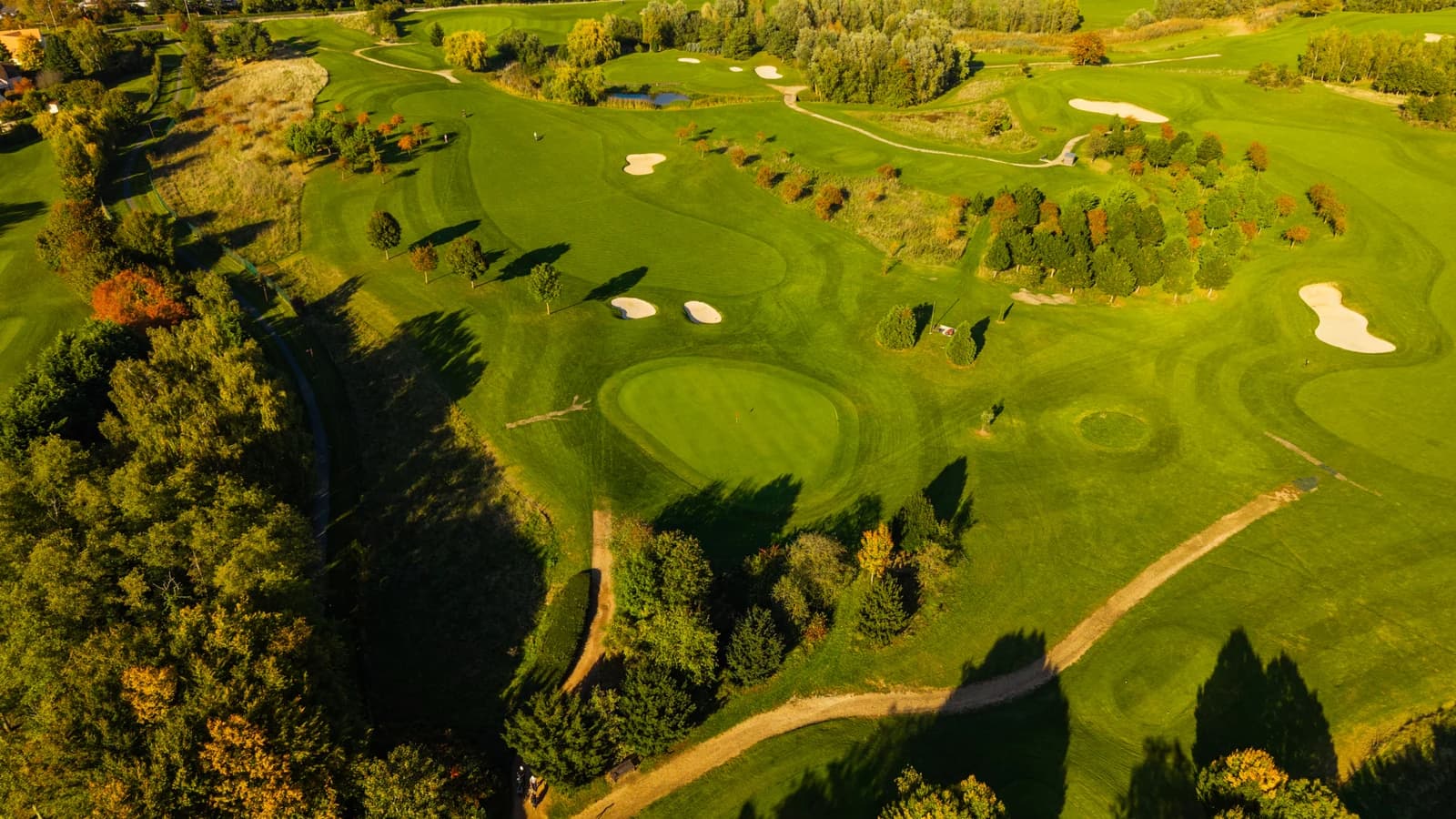 Vue aérienne du Golf de Bussy-Guermantes montrant les fairways, les greens et les bunkers dans un paysage boisé.