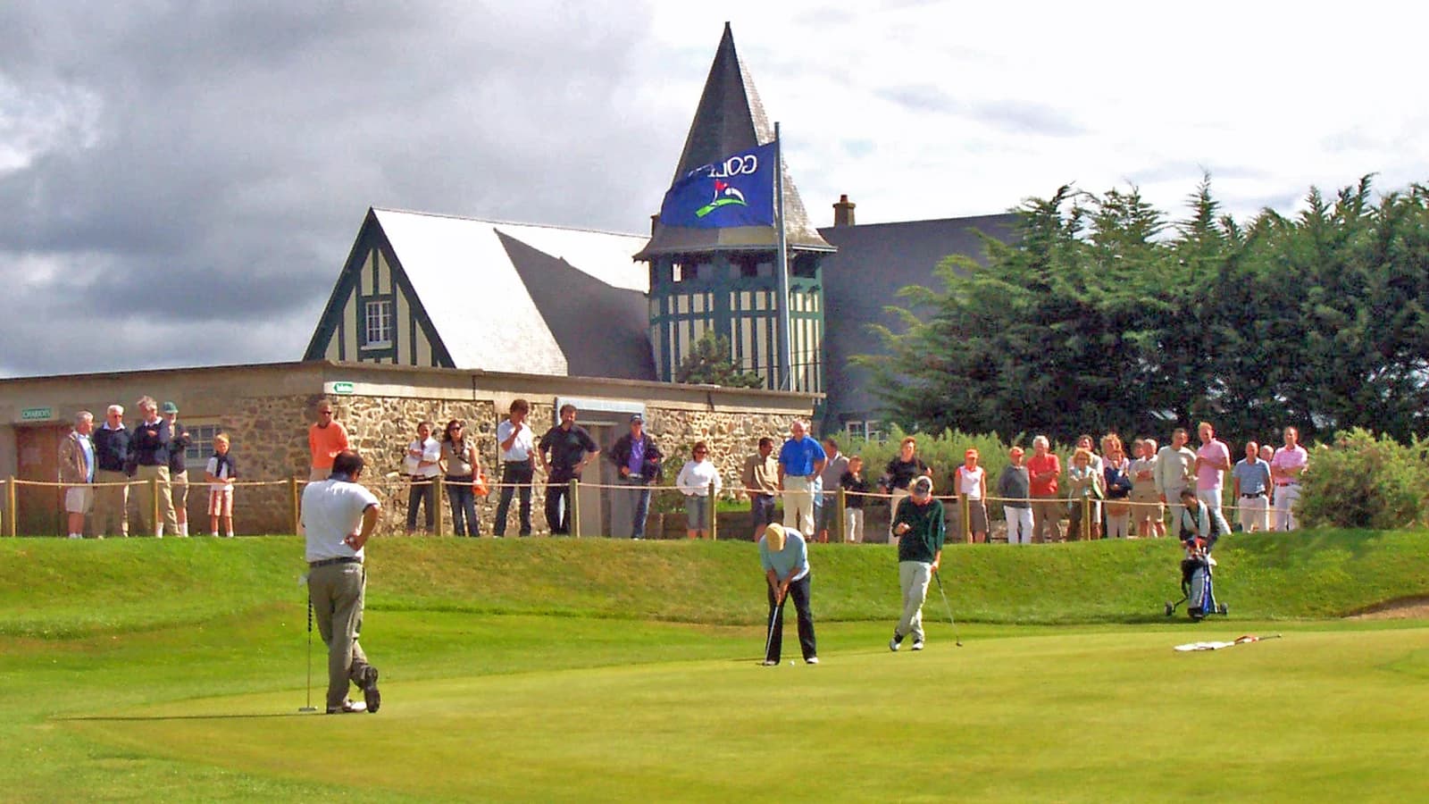 Golfeurs sur le green du Golf de Granville devant le club-house.