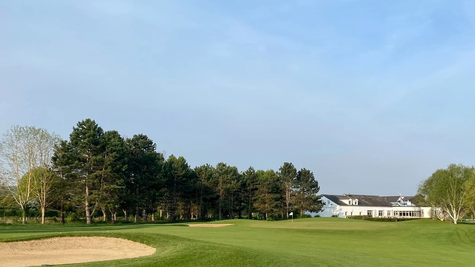 Vue du green et du fairway du Golf de Léry-Poses devant le club-house.