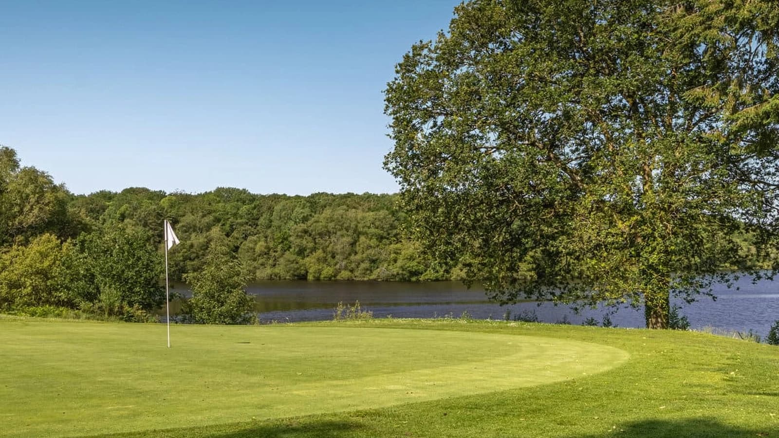 Green et drapeau de l’Old Course devant l’étang de Mirloup au Golf de Saint-Malo.