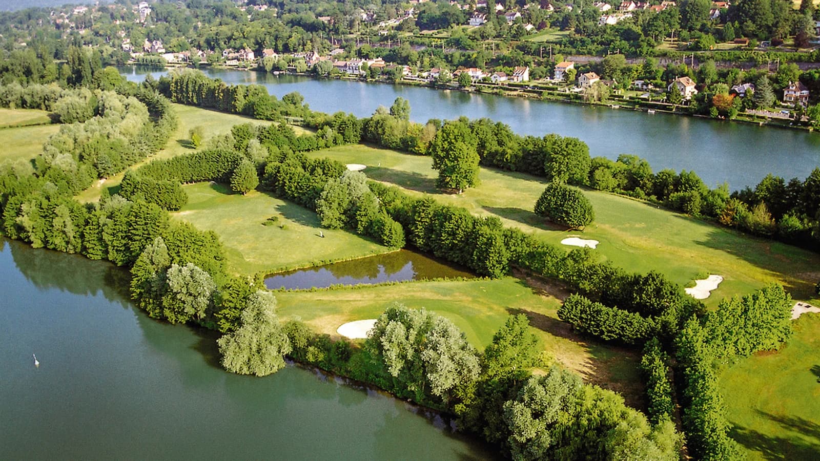 Vue aérienne du Golf UCPA de Bois-le-Roi entre les fairways, les plans d’eau et la Seine.
