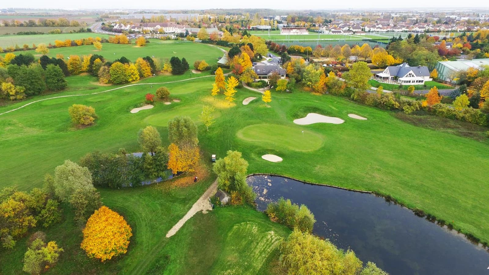 Vue aérienne d’UGOLF Gonesse montrant les fairways, les bunkers et les plans d’eau.