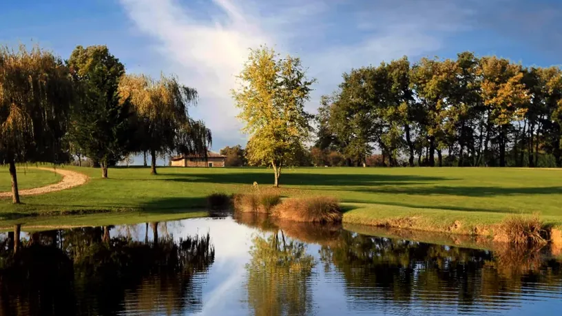 Green et obstacle d’eau avec arbres en couleurs automnales.