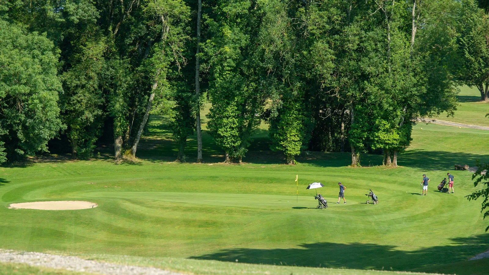 Golfeurs sur un green bordé de bunkers ; scène différente du bassin.