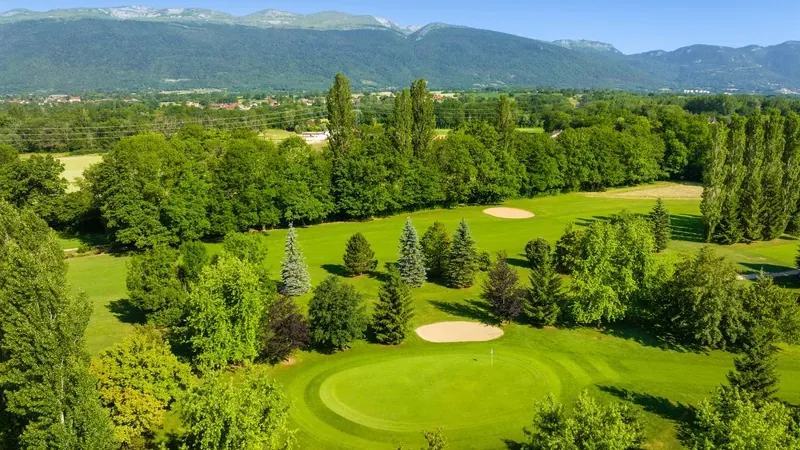 Vue aérienne des greens et bunkers de La Manchette devant le massif du Jura.