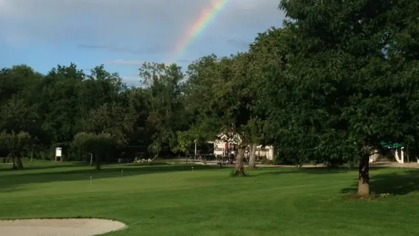 Green, bunker et arc-en-ciel au-dessus des arbres.