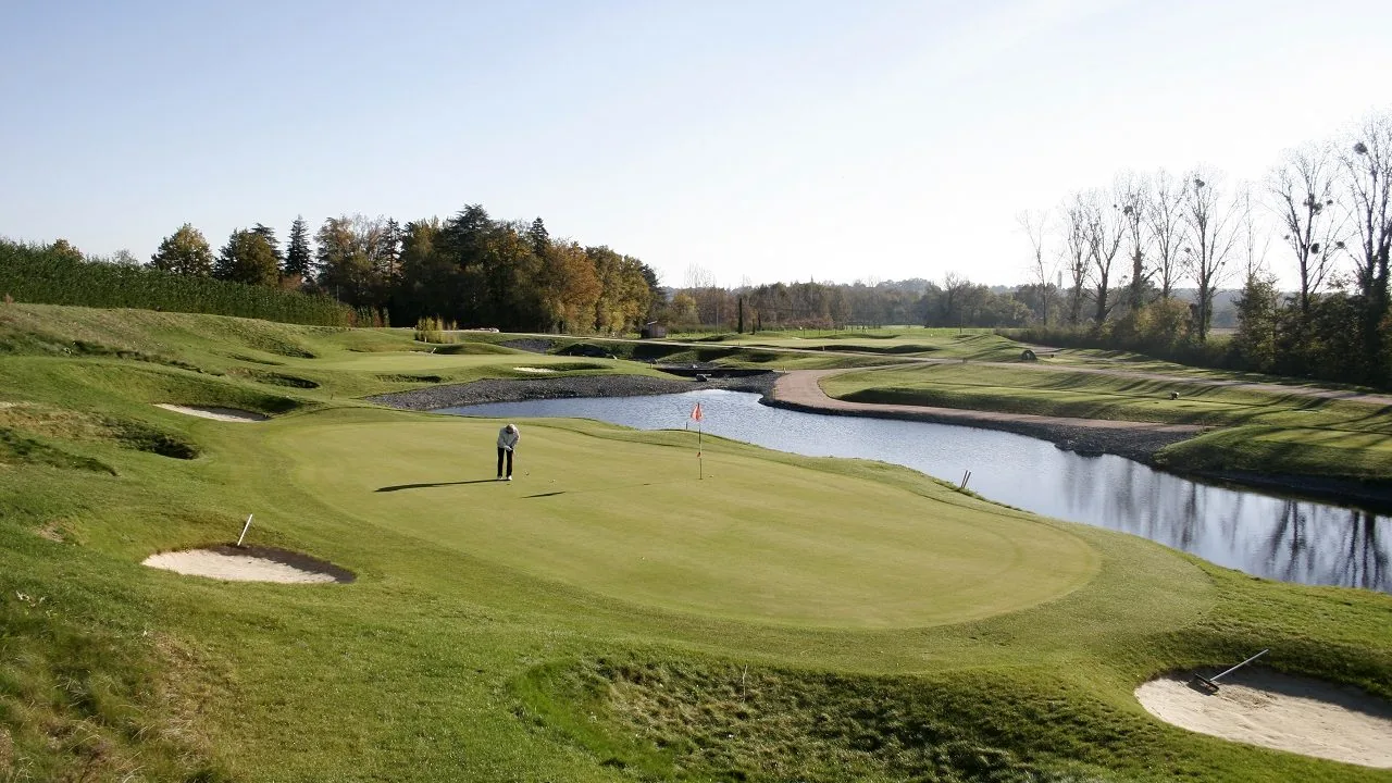 Green, golfeur, bunker et obstacle d’eau.