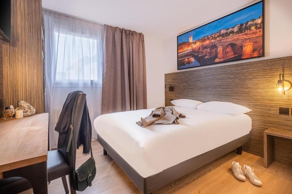 une chambre d'hôtel avec un grand lit et un bureau dans l'établissement Sure Hotel by Best Western Angers Sud, à Les Ponts-de-Cé