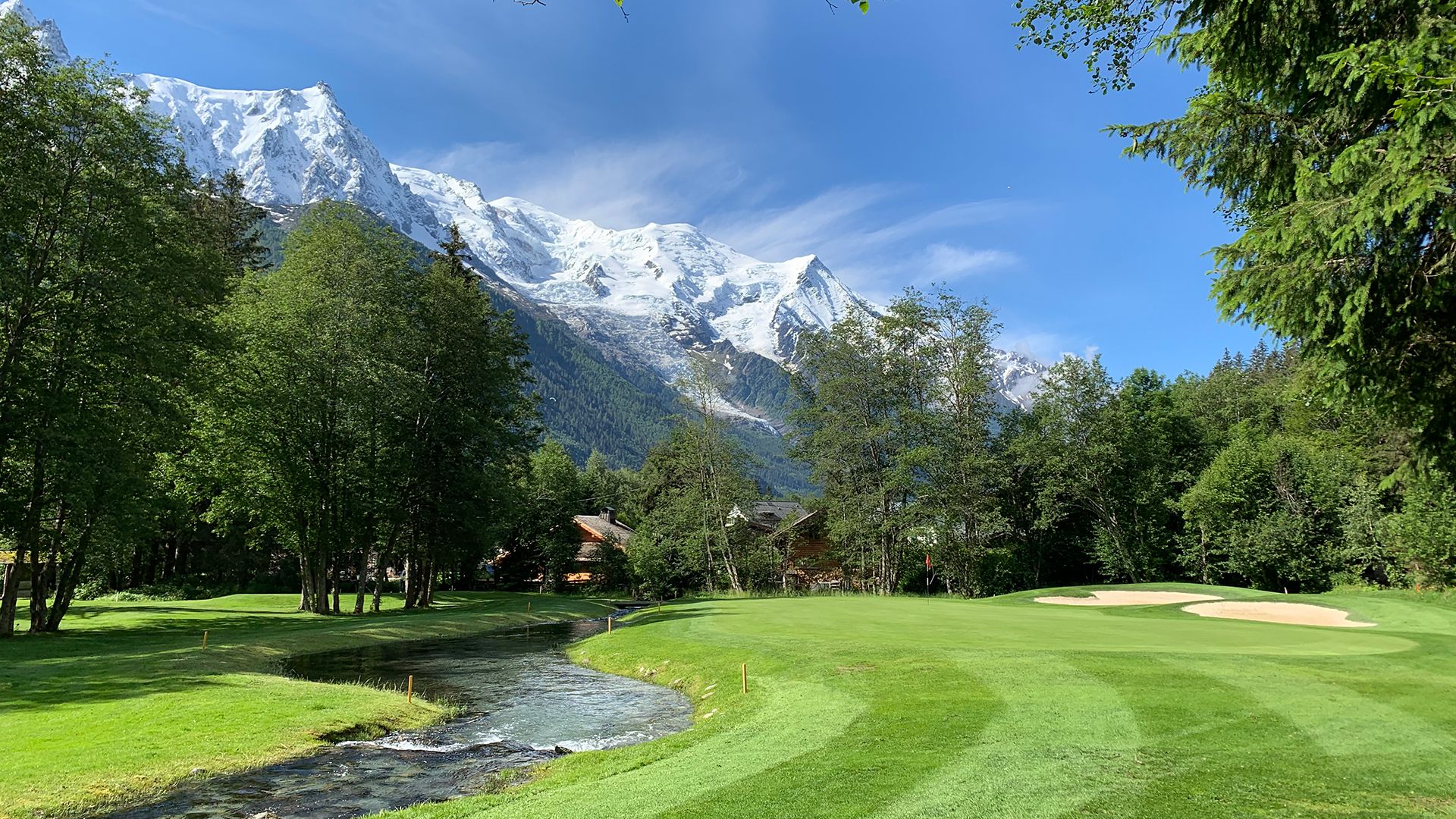 Fairway du golf de Chamonix au pied des sommets enneigés.
